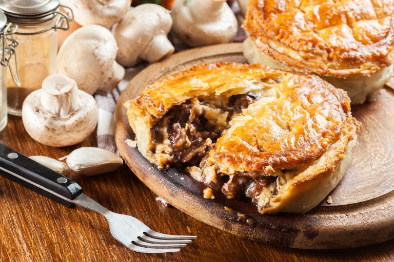 Fresh beef stew pie on a cutting board. Meat in puff pastry