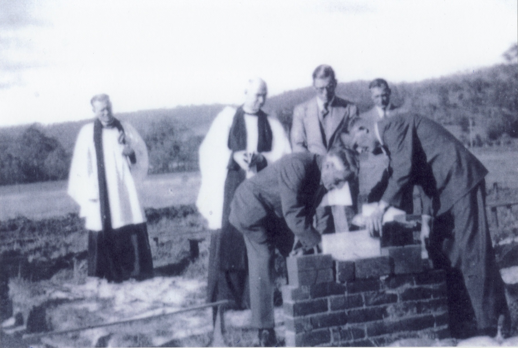 Priests and men laying foundation stone