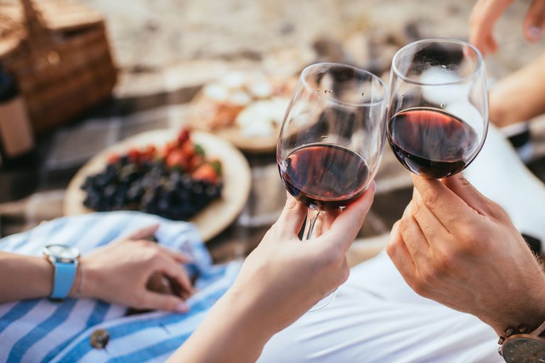 selective focus of man and woman clinking glasses with red wine