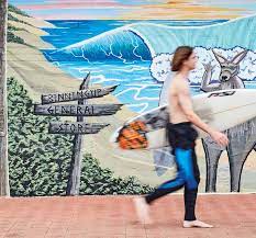 Image of a person walking past a mural signposting the Binningup General Store