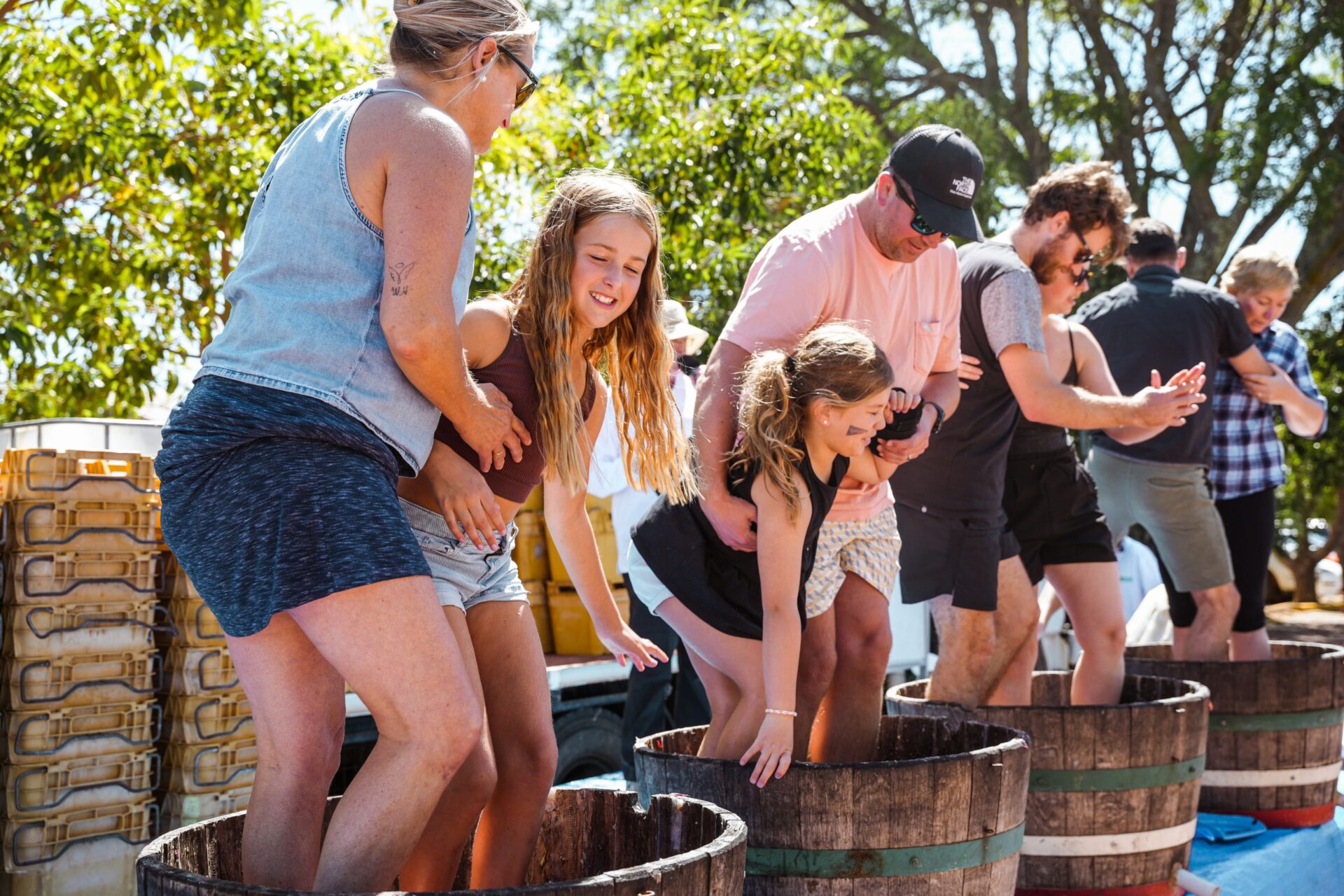 Image of people stomping grapes in half wine barrels