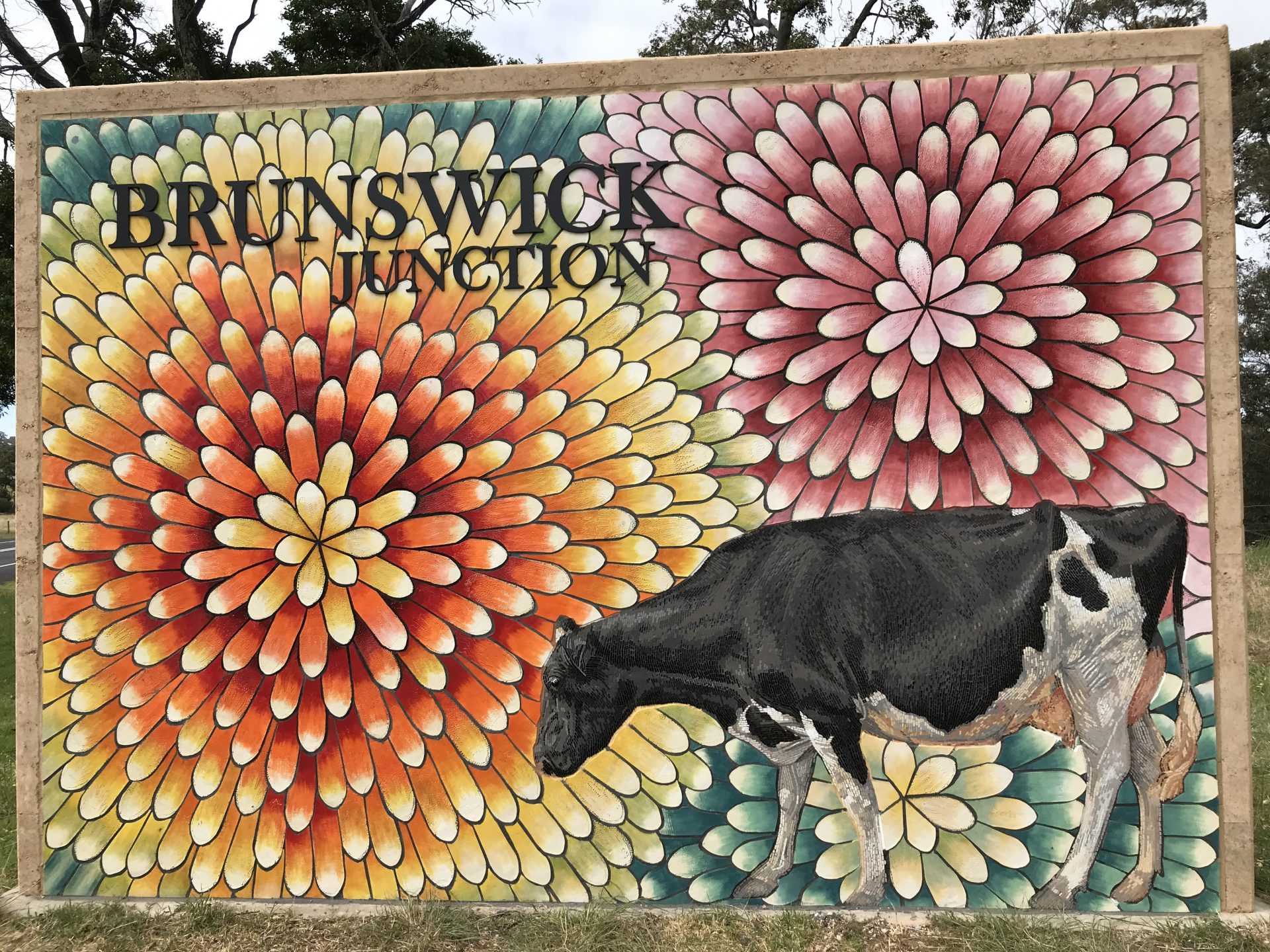 Picture of the Brunswick Mosiac Entry Statement containing a Cow and flowers in the background