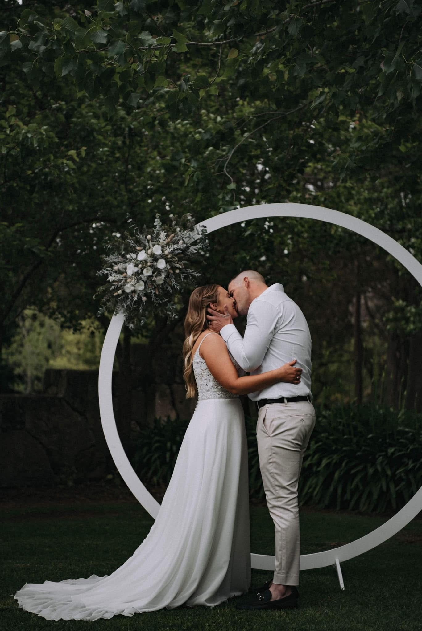 Image of a husband and wife kissing in front of a backdrop