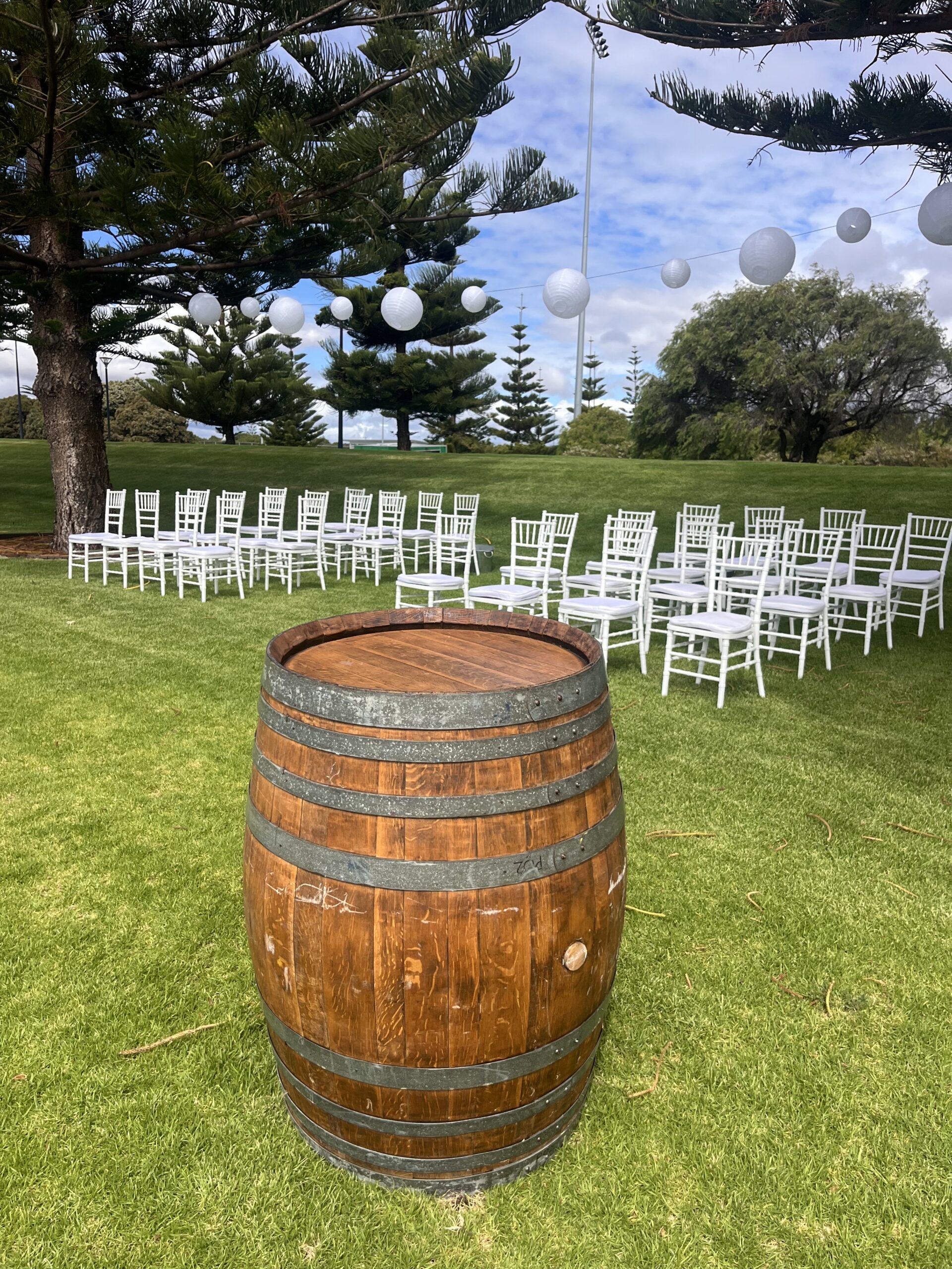 Image of a wine barrel with white chairs in the background